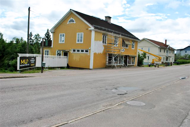 Målning av husfasad med släpvagnslift